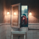 Natasha Lyonne peeps through an out-of-place window into a bathroom in a scene from Russian Doll season 2.